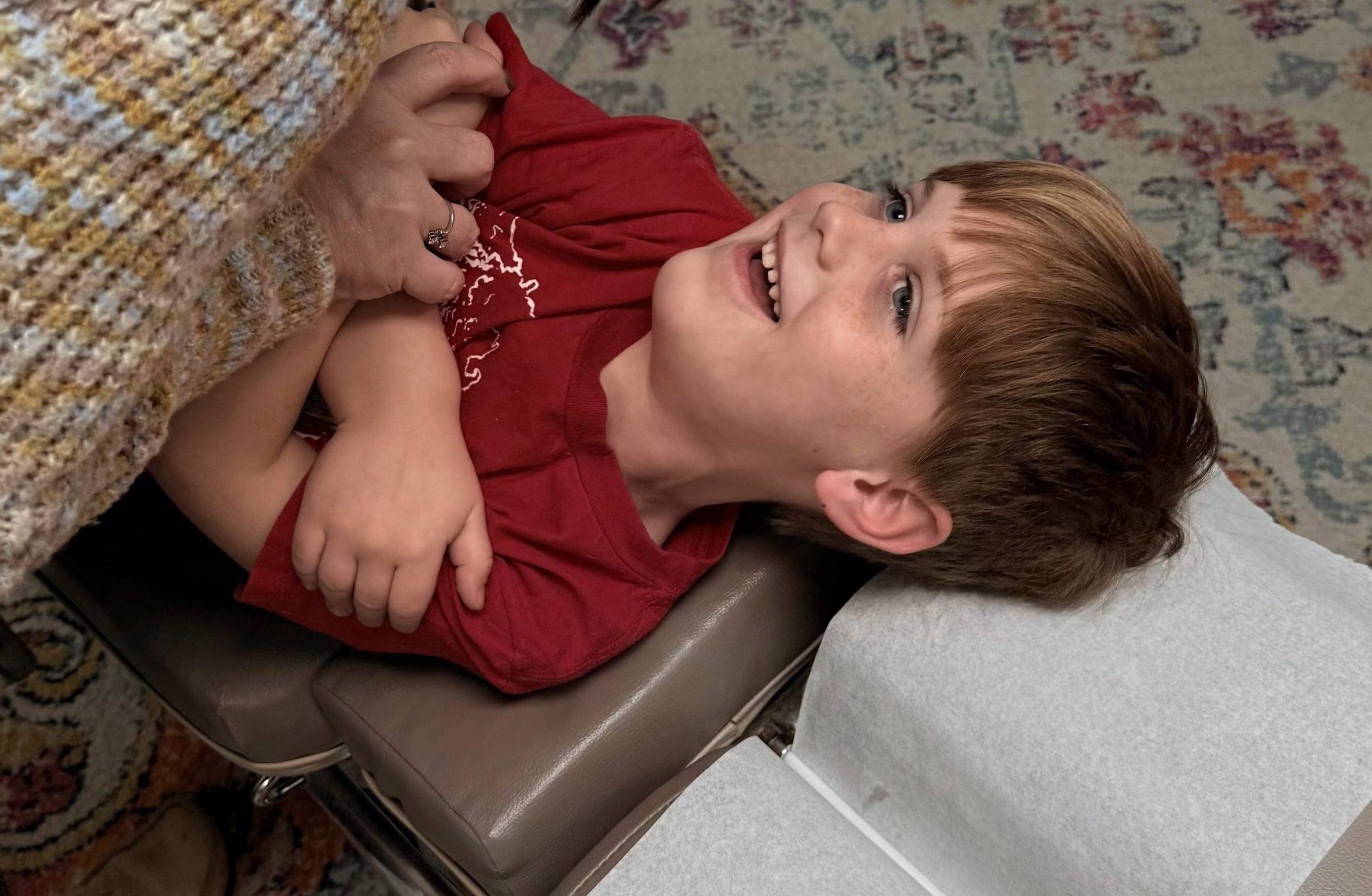 Happy youth getting adjusted by Magnolia Tribe Chiropractor